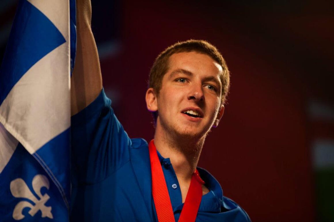 Event photo of a student from the province of Quebec celebrating their victory after receiving a medal during the closing ceremony.